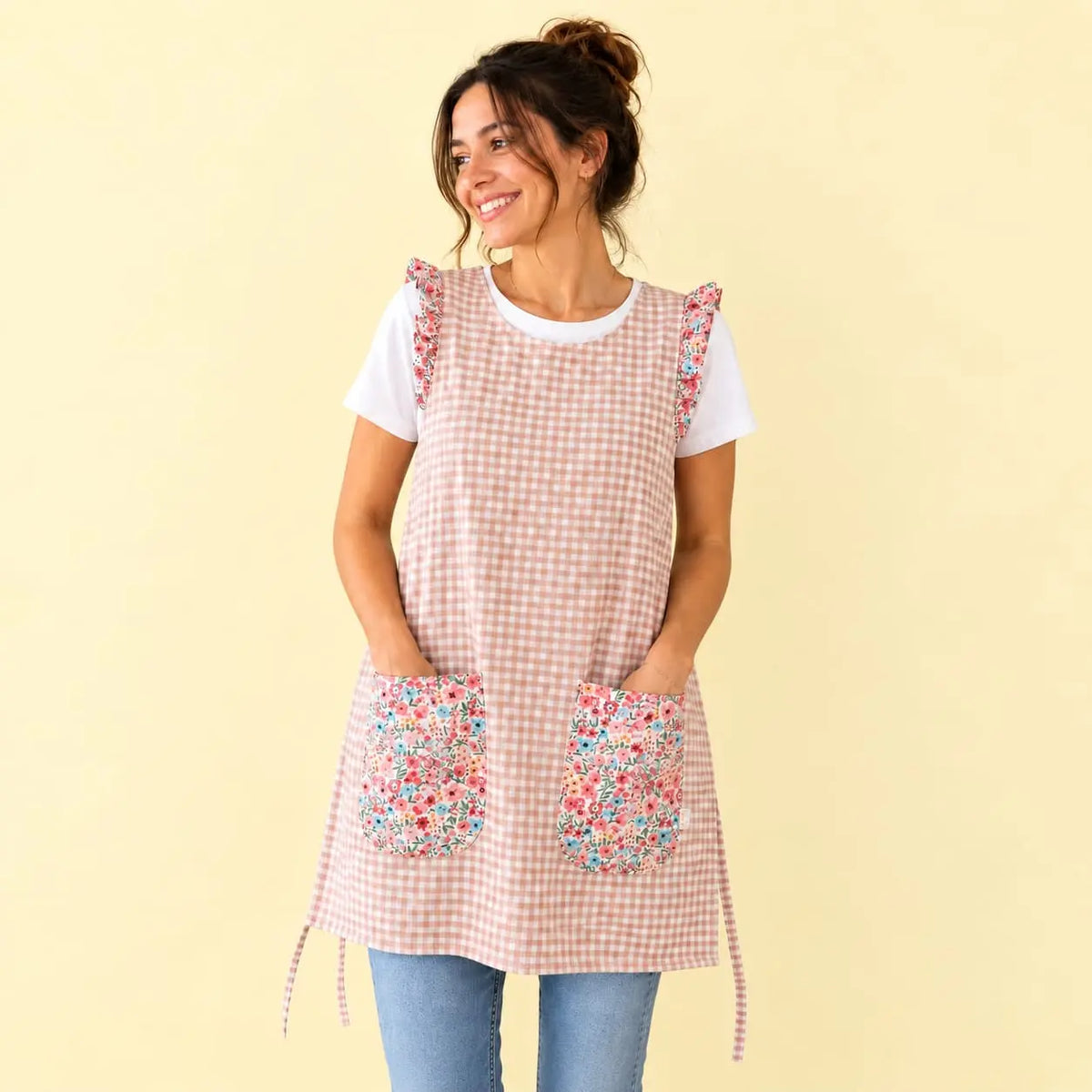 Modelo con estola de cuadros rosa claro, volantes y dos bolsillos estampados de flores rosas y turquesas.