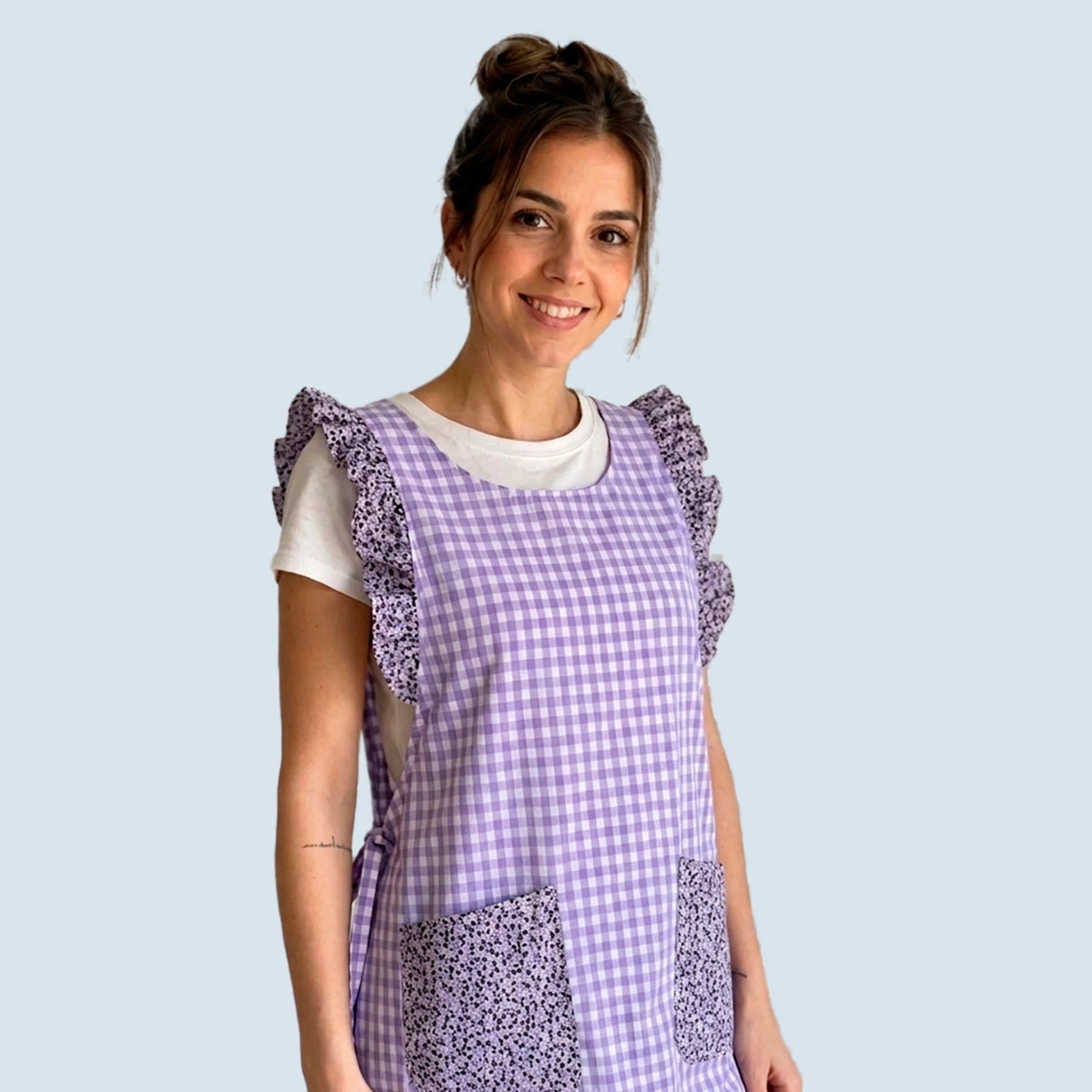 Estola de cuadros lavanda con volantes y dos bolsillos de pequeñas flores moradas.