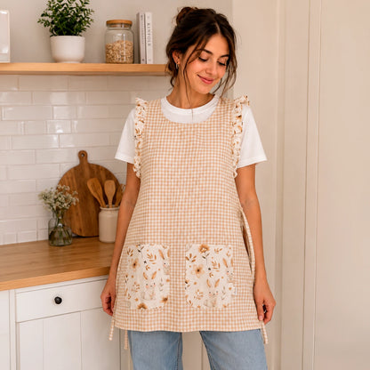 Modelo en una cocina con estola de cuadros beige, volantes y dos bolsillos de conejitos y flores.