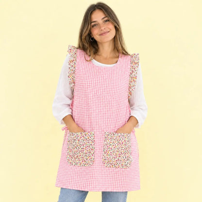 Modelo con estola de cuadros rosas, volantes florales y dos bolsillos de pequeñas flores.