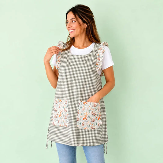 Modelo con estola de cuadros verde grisáceo, volantes y dos bolsillos con animales del bosque.