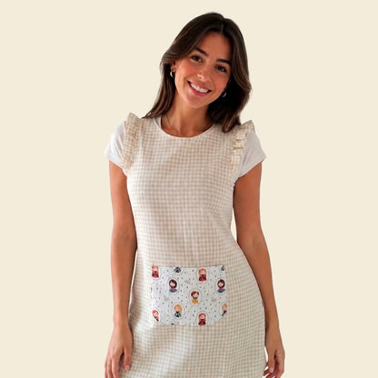 Modelo con estola de cuadros beige, volantes y bolsillo central con ilustraciones de princesas.