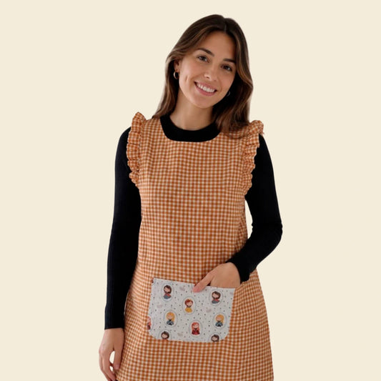 Modelo con estola de cuadros mostaza, volantes y bolsillo central blanco estampado de princesas.